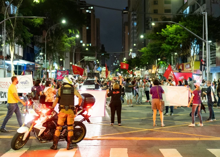 a police motorcycle in front of protesters on the street