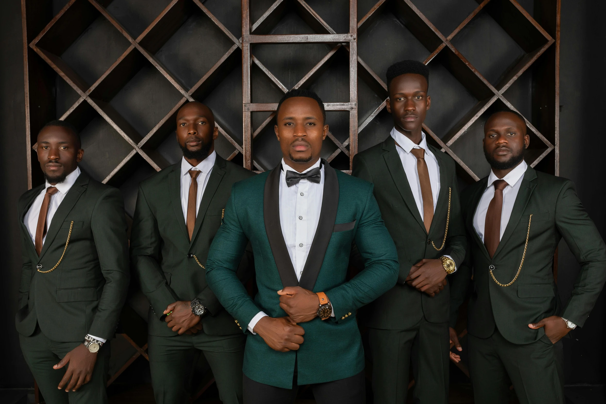 a group of men wearing green suits, ties and celets