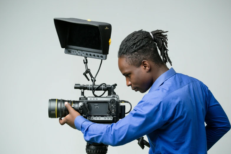 a man with dreadlocks is holding a camera and making a video