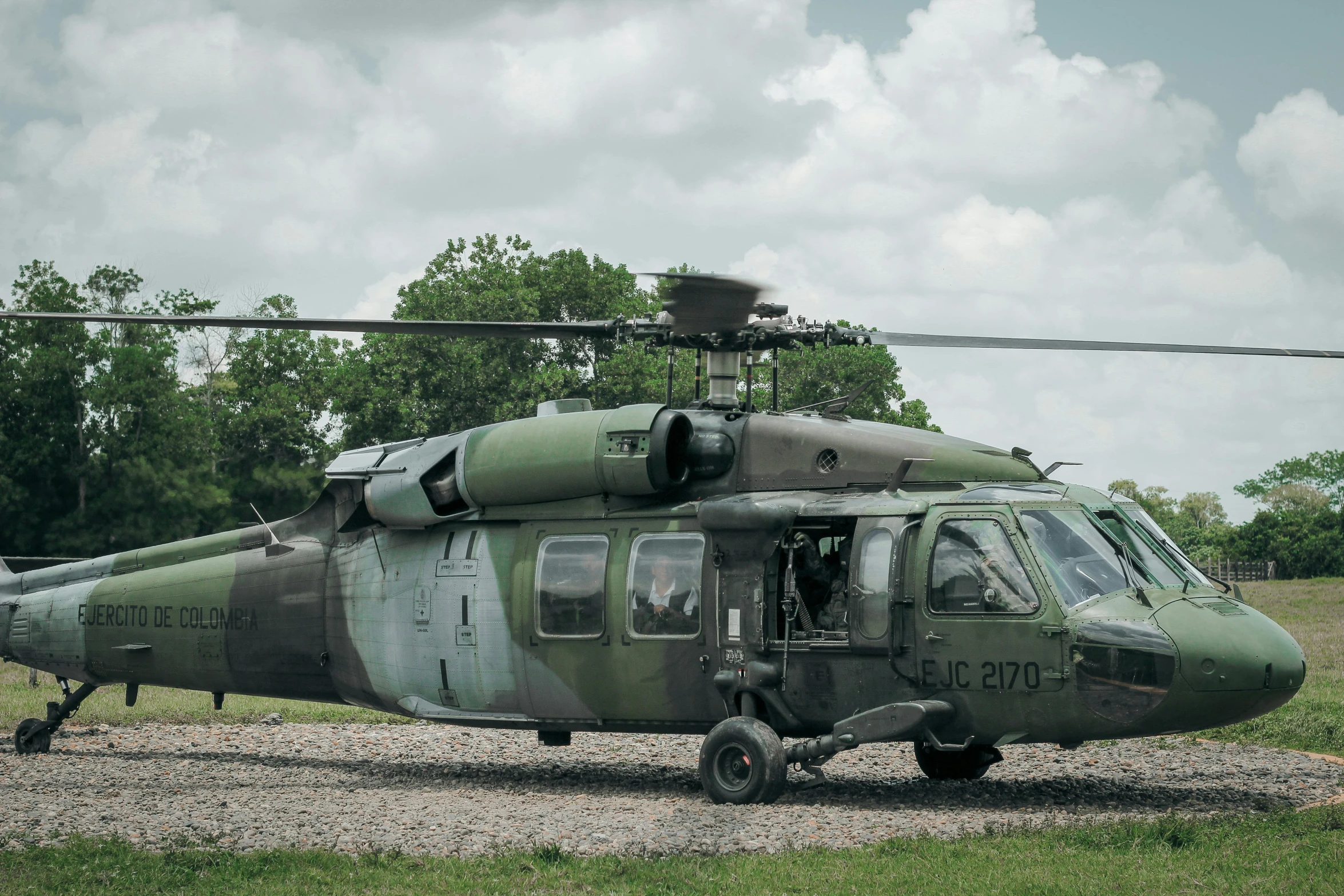 a military helicopter sitting on top of a field