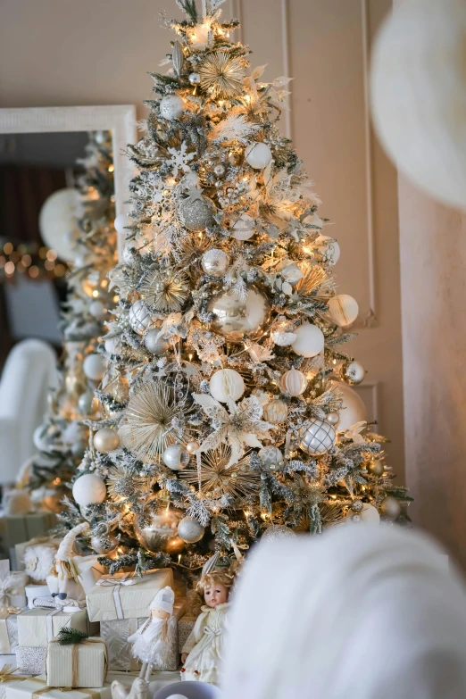 a white christmas tree with silver and gold ornaments