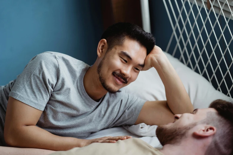 a man and a young man laying in bed