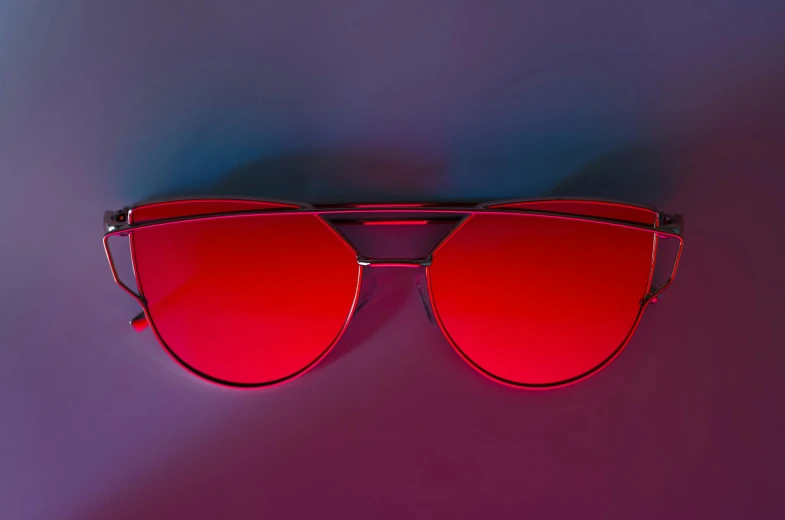 red mirrored sunglasses that are laying on the ground