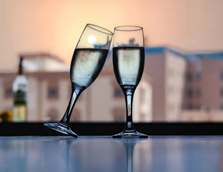 two champagne flutes with bubbles on a table