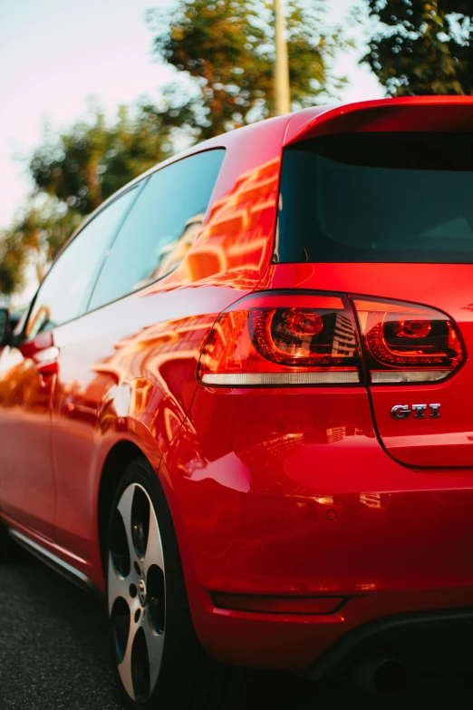 the back end of a red car with its lights on