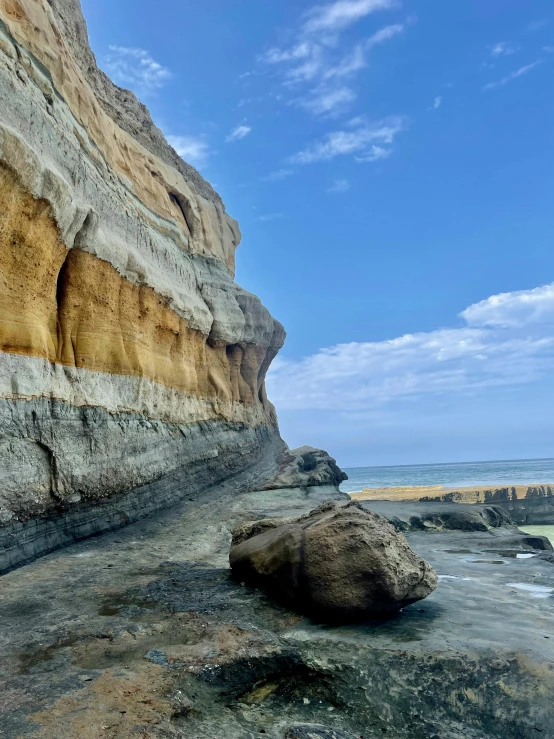 some rocks some water and a cliff face