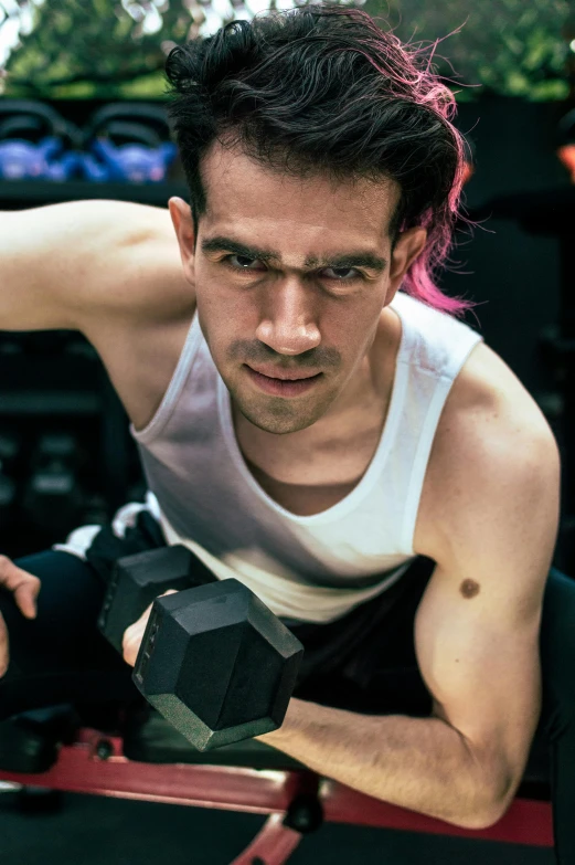 a man laying on the ground holding two dumbbells