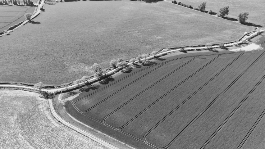 an aerial s of a train track running through a wide, open field