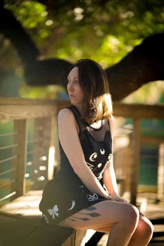 young woman sitting on wooden bench with her arms on chest and shoes bent to the side