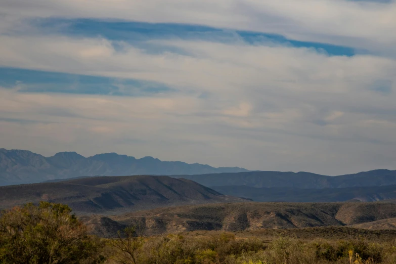 there are several tall hills and trees on this desert