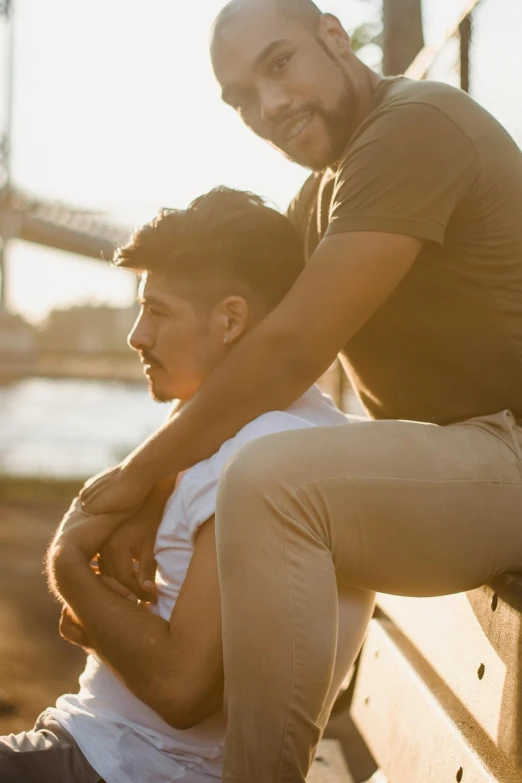 two young men are sitting on top of a bench