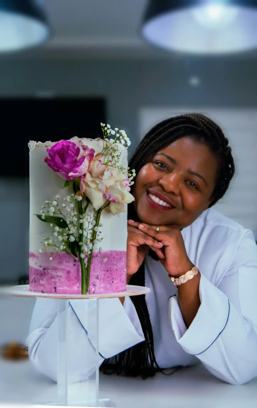 a woman holding a cake that has been decorated with flowers