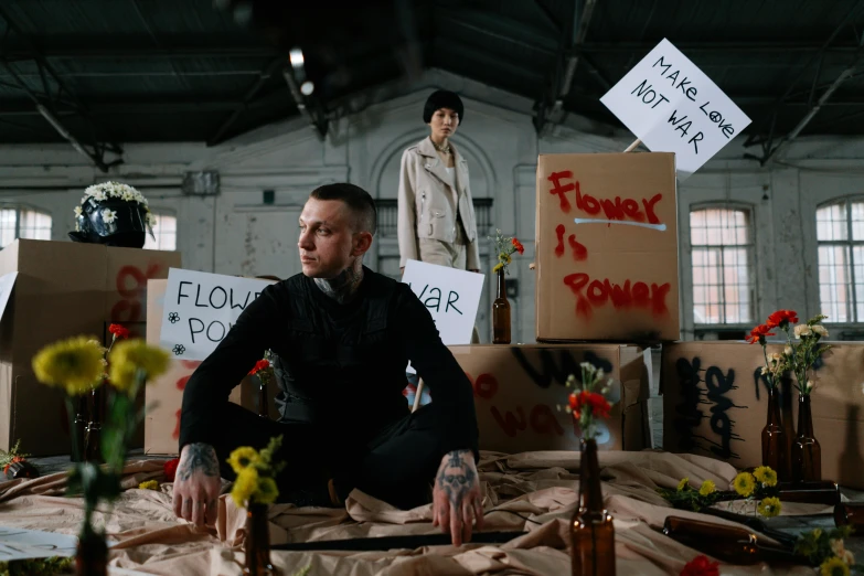 a man sits in front of many flowers