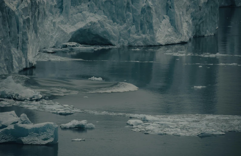 large icebergs near water in front of a glacier