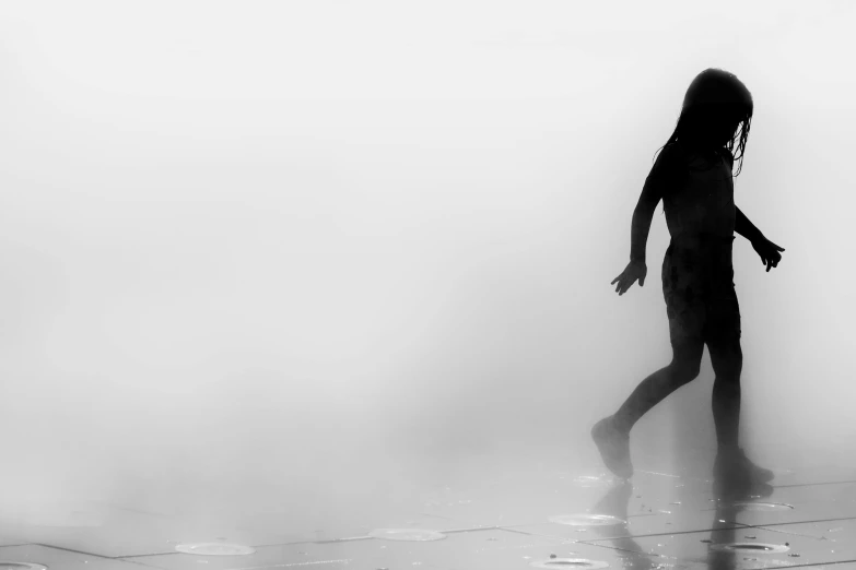 a person in a black suit standing in the mist