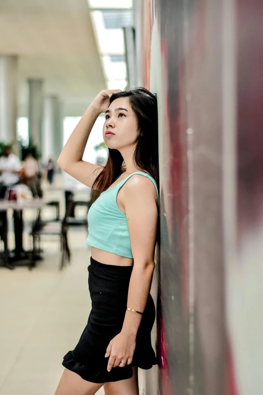 a woman standing in front of a wall posing for the camera