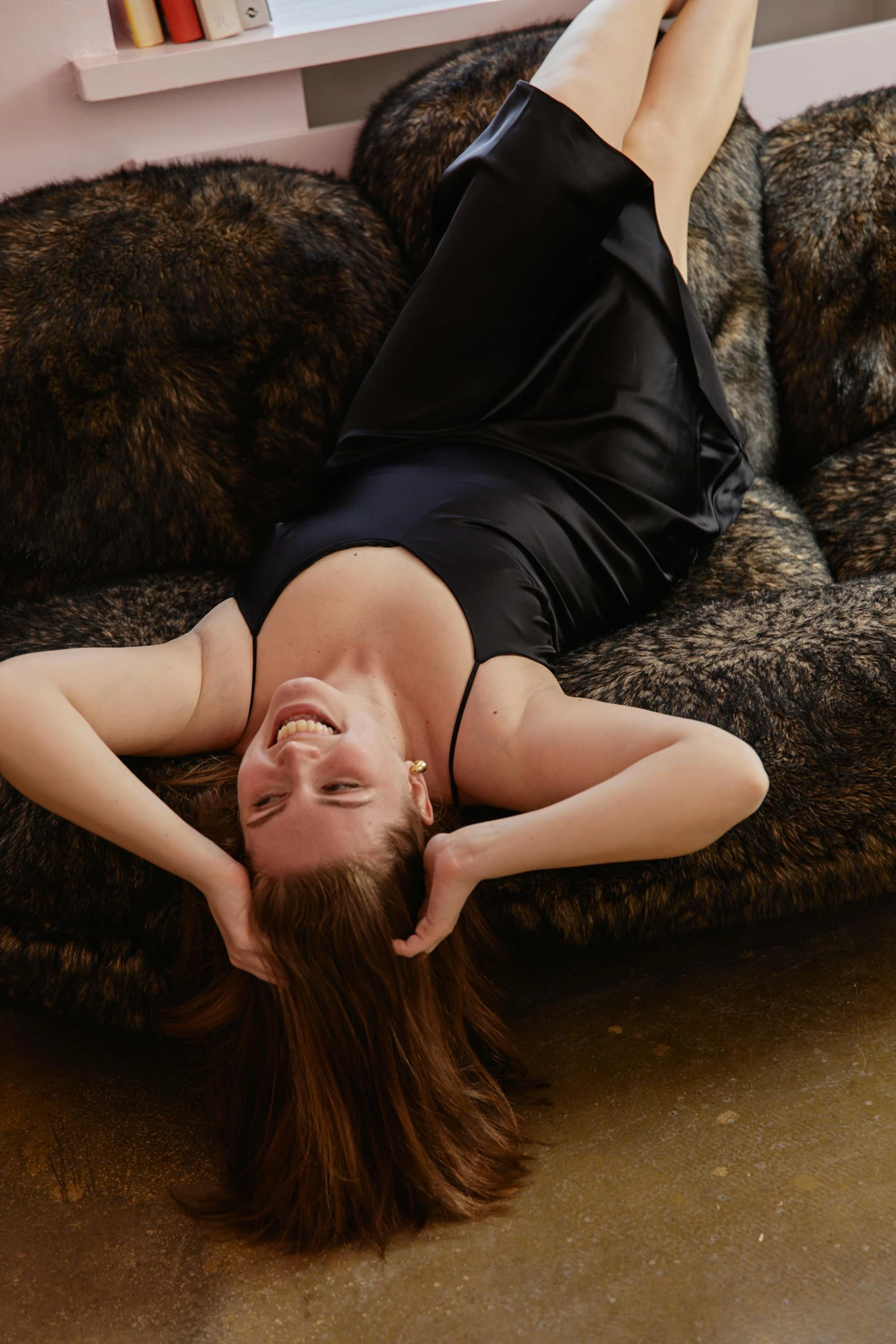 a woman in a black dress lays on a couch