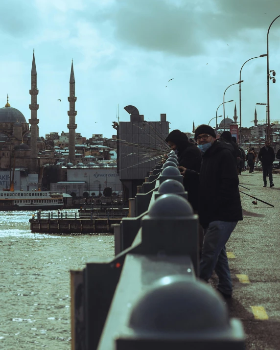 people walking by the riverbank in the city