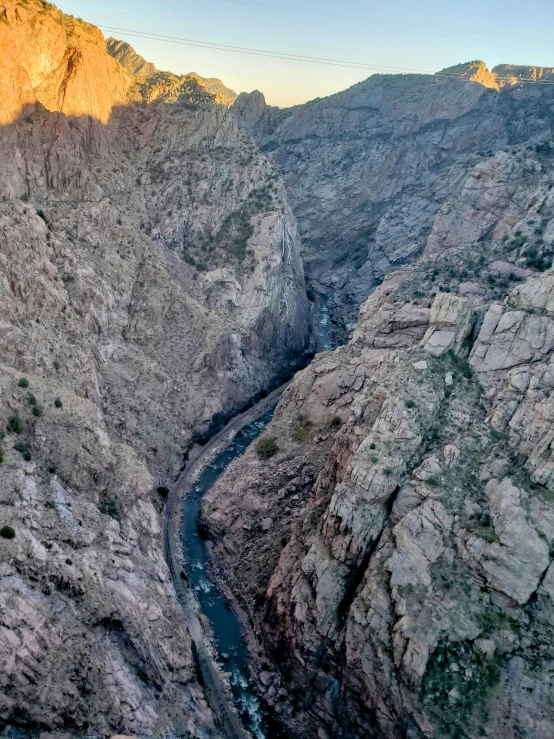 a river flowing between some very large rocky hills