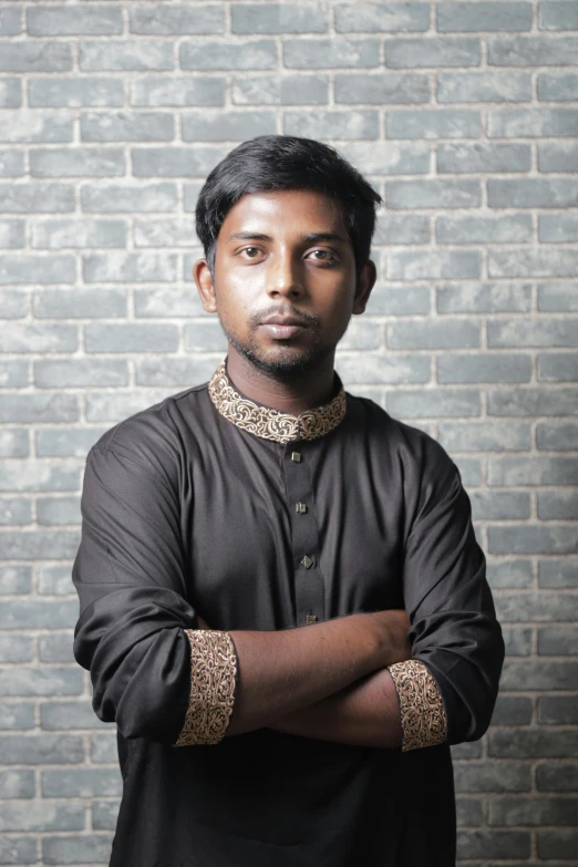 a man in black is standing with his arms crossed