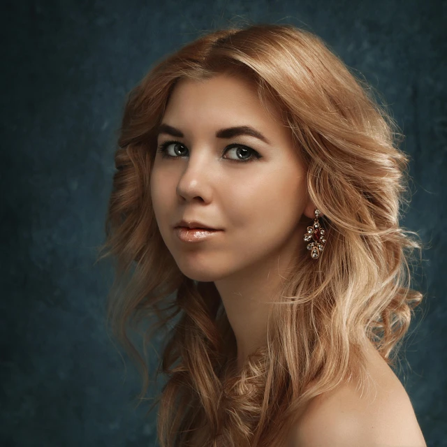 an attractive blonde woman with brown eyes and large earrings