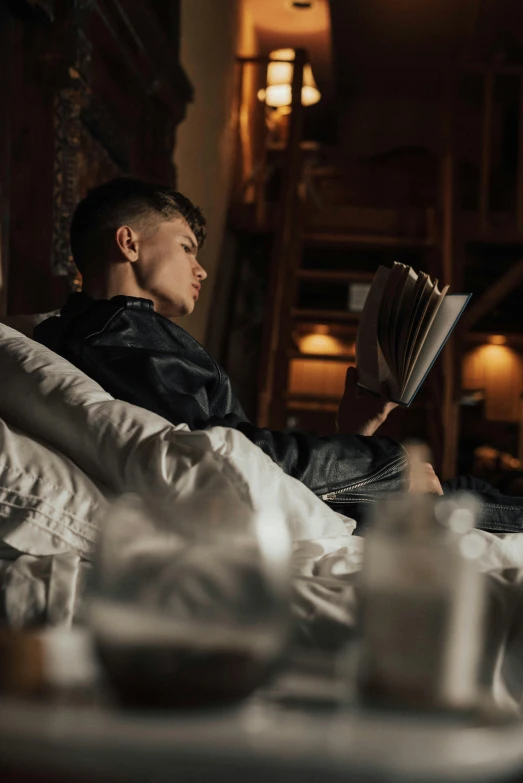 a man in bed reading a book at night