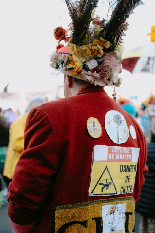 there is a person wearing a red jacket with an unusual hat on their head