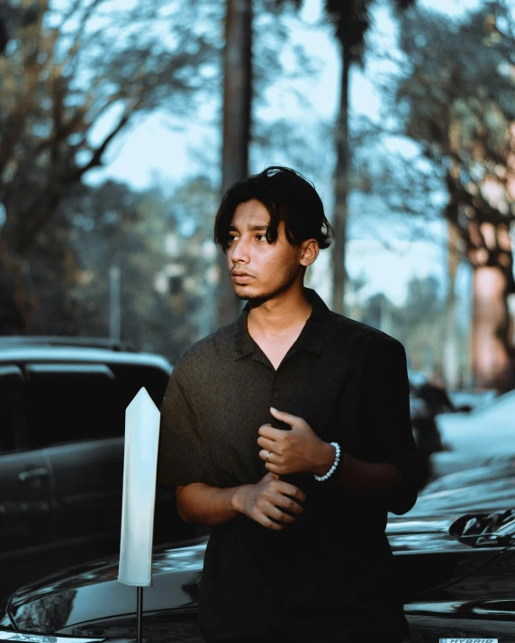 man leaning against pole in city setting with cars