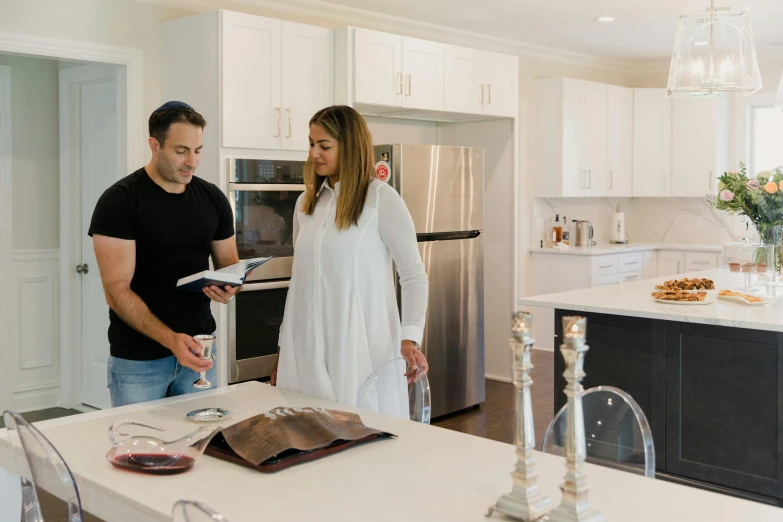 a man and woman are looking into a refrigerator