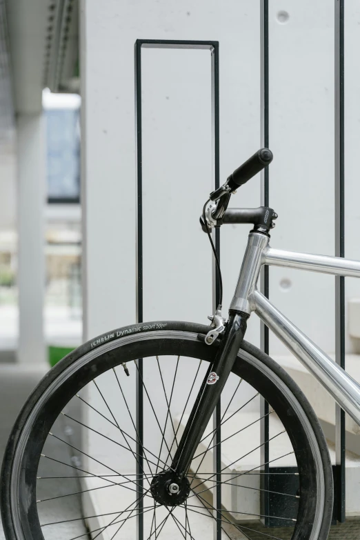 a bicycle with no front wheel resting against the fence