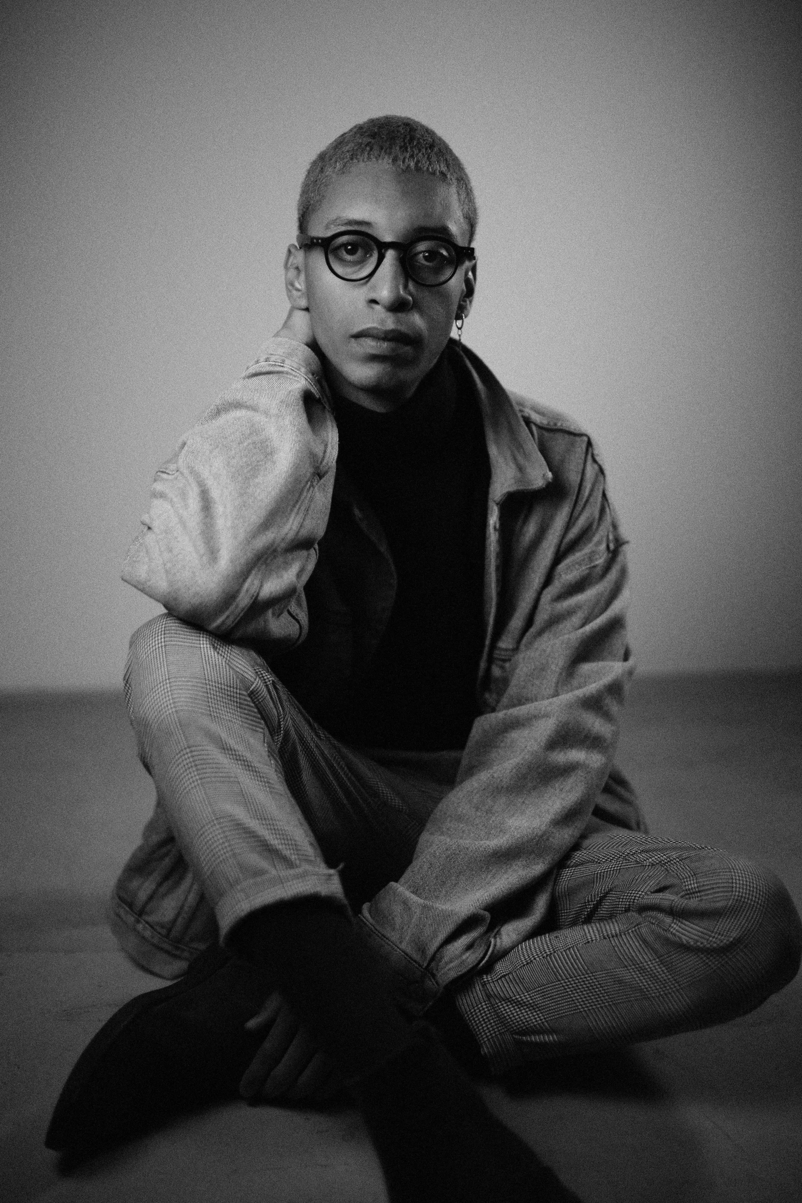 a black and white image of a person sitting on the ground