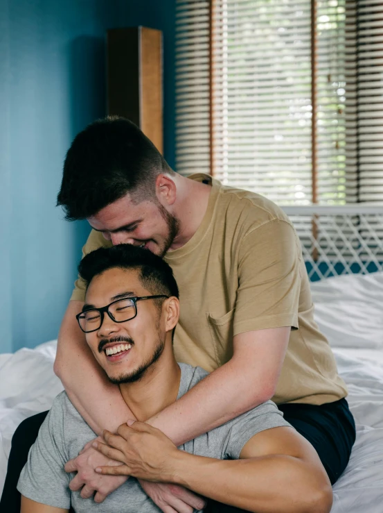 two men in glasses emcing on the bed