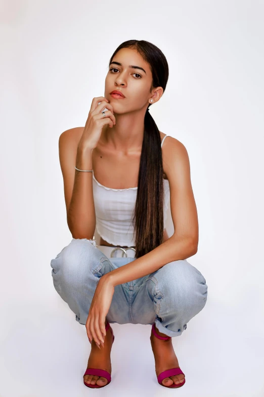 a woman sitting on the ground with her finger to her mouth