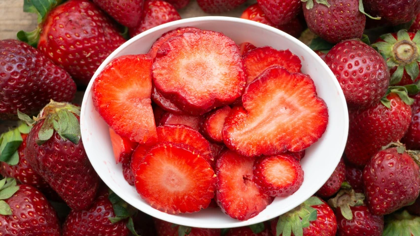 some strawberries are in a white bowl