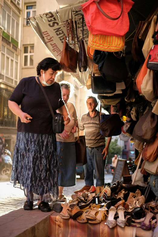 a woman that is standing near a bunch of shoes