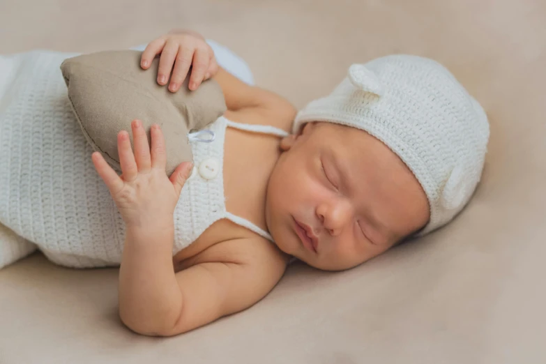 a baby is dressed in a diaper and is holding a stuffed animal