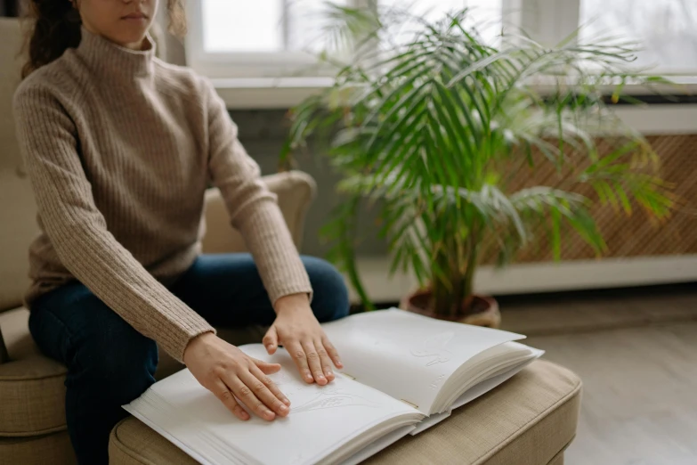 a lady is sitting on the floor with a book in front of her