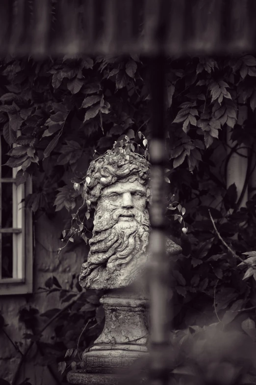 a statue in a garden next to the house