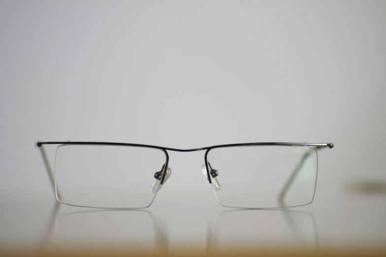 a pair of eyeglasses are pictured sitting on a table