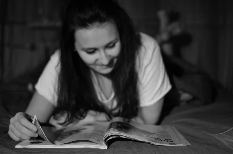 there is a woman reading a book with an open page on the table