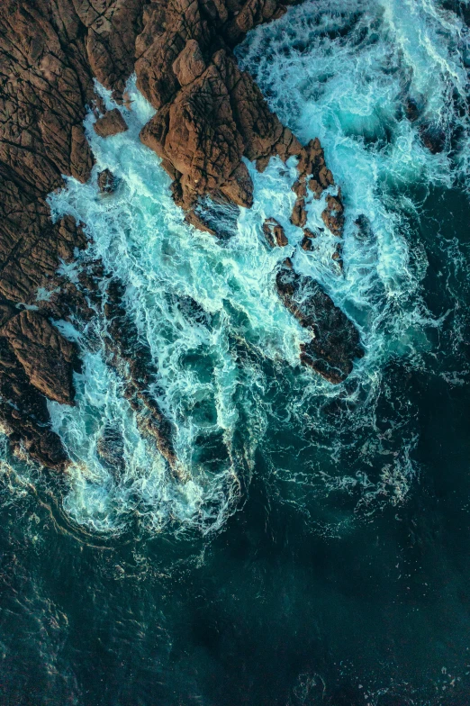 an aerial view of the rocky coastline and ocean waves