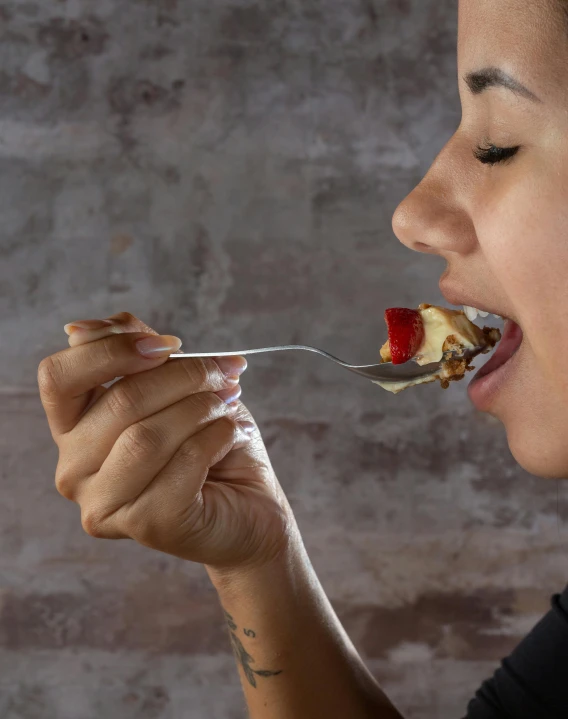 a woman taking food out of her hand with a fork