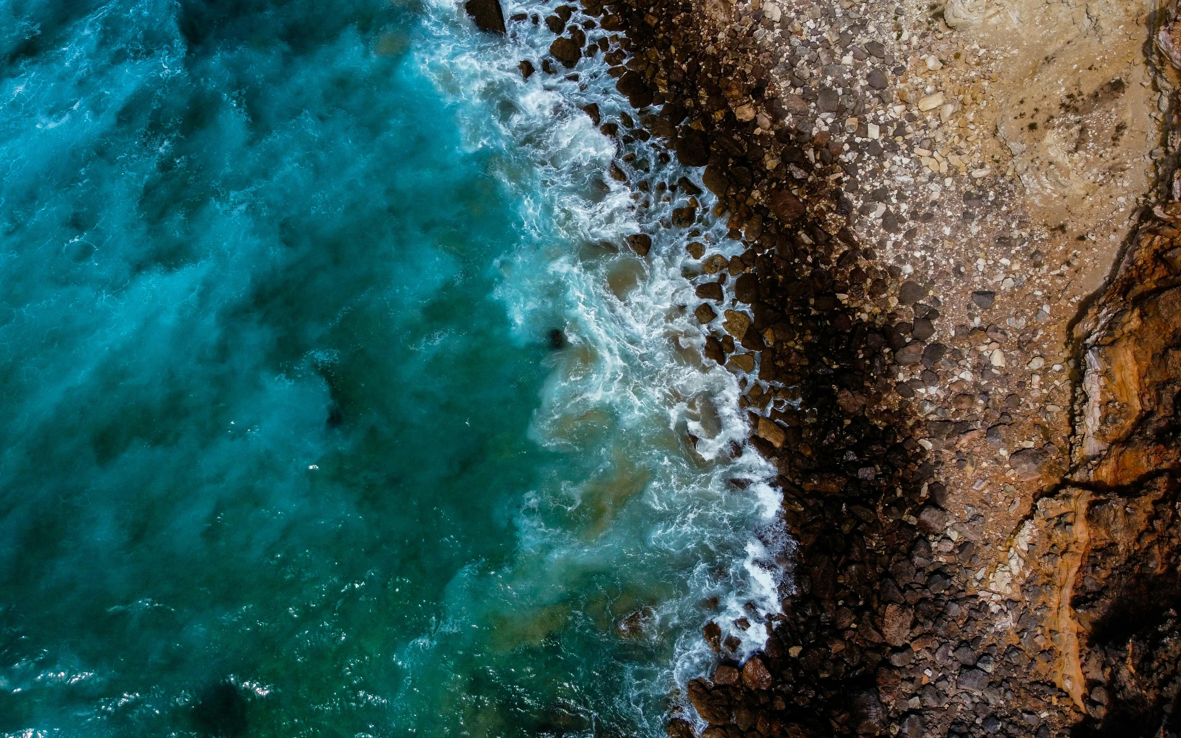 water and rock on an ocean surface from above