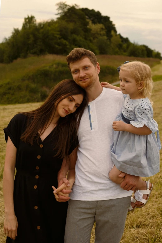 a family is posing for the camera while holding their baby