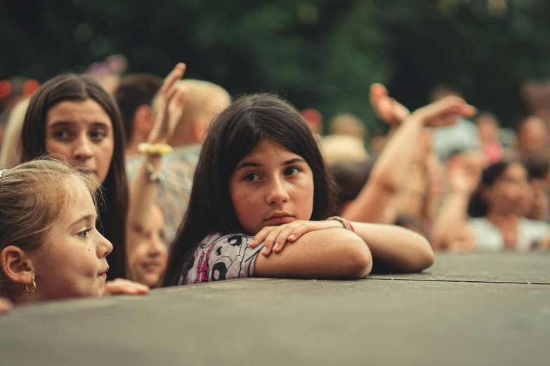 children watch as another girl hides her face behind her