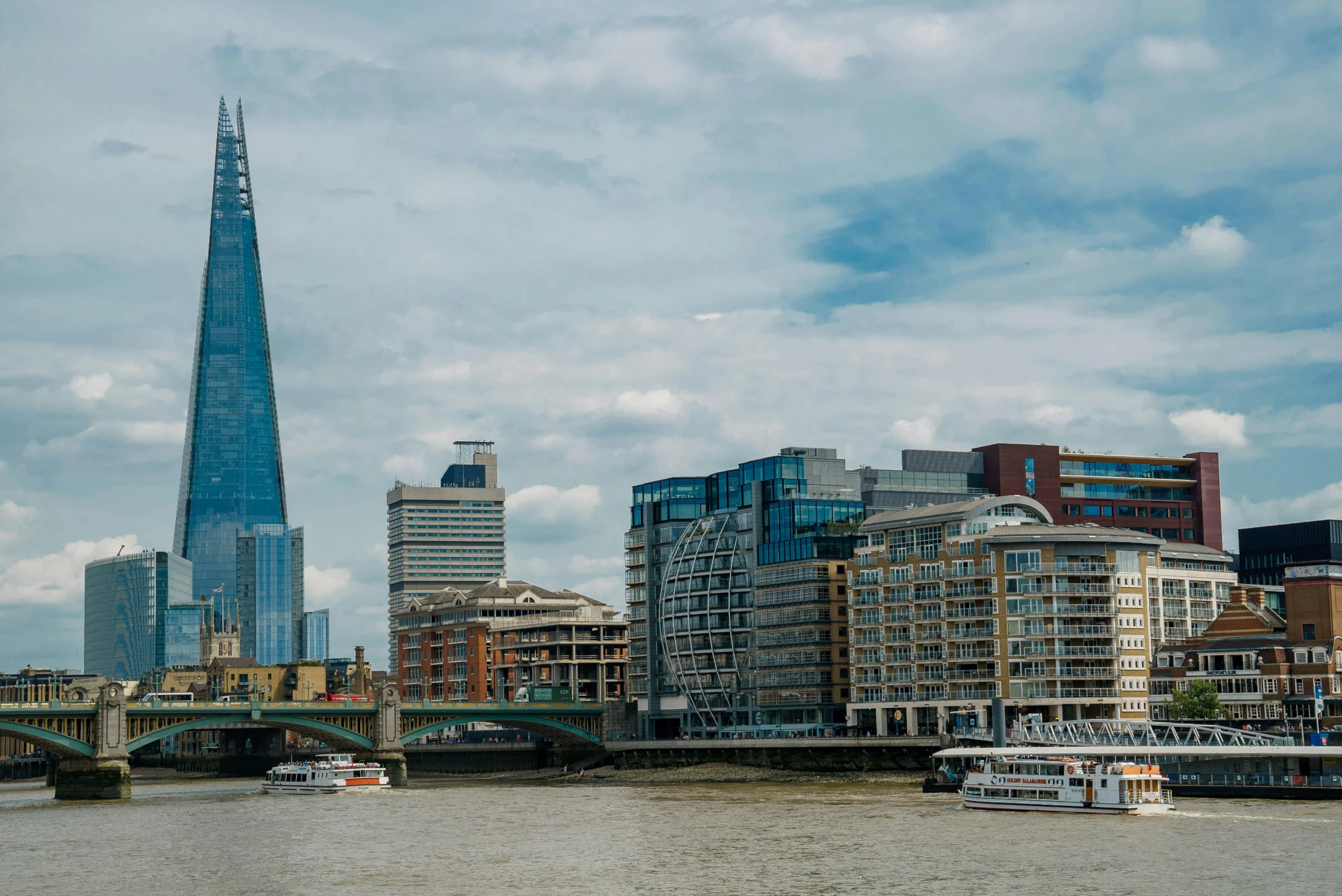 the river with a boat passing by city buildings