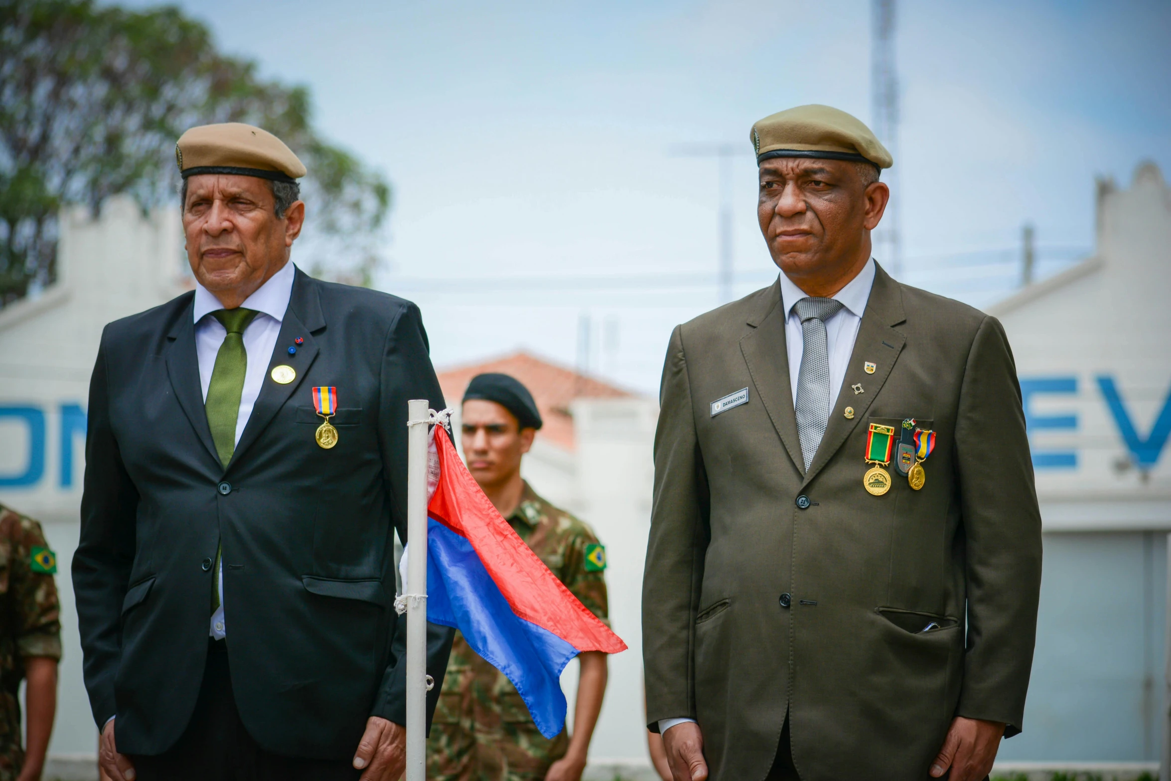 two men with military ties are holding flags