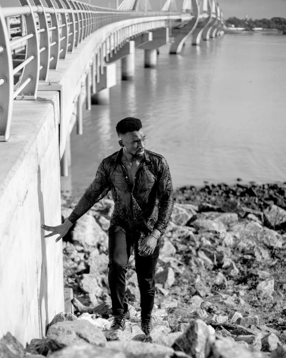 a man leans against the rocks beside water