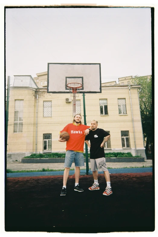 a young man with an older man with a basketball at the net