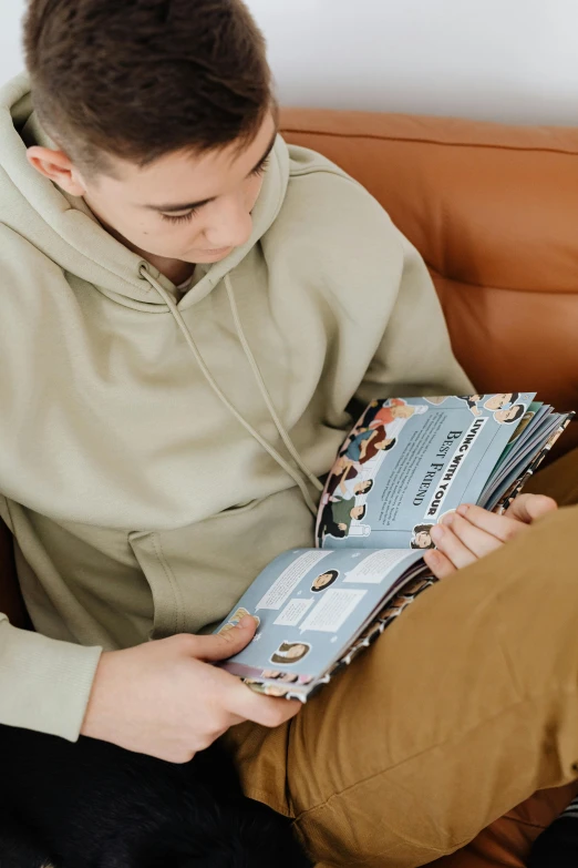 a man is reading a magazine on a couch